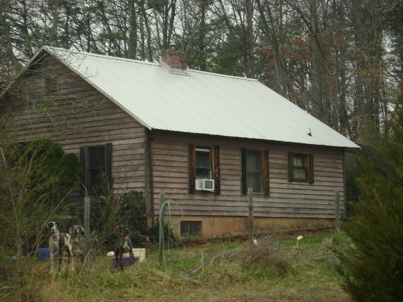 White metal roof on an old wood sided farmhouse, from a Asphalt Shingle Roof Repair job in Fayetteville